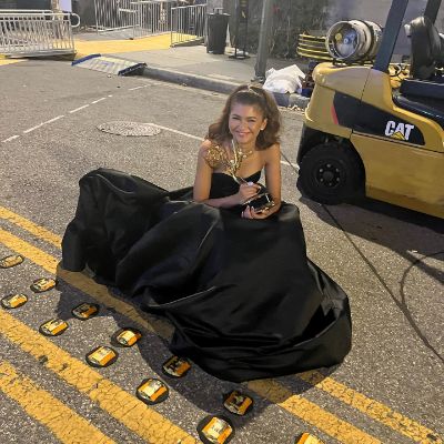 Zendaya Maree Stoermer posing for a photo shoot while holding an Emmy award.